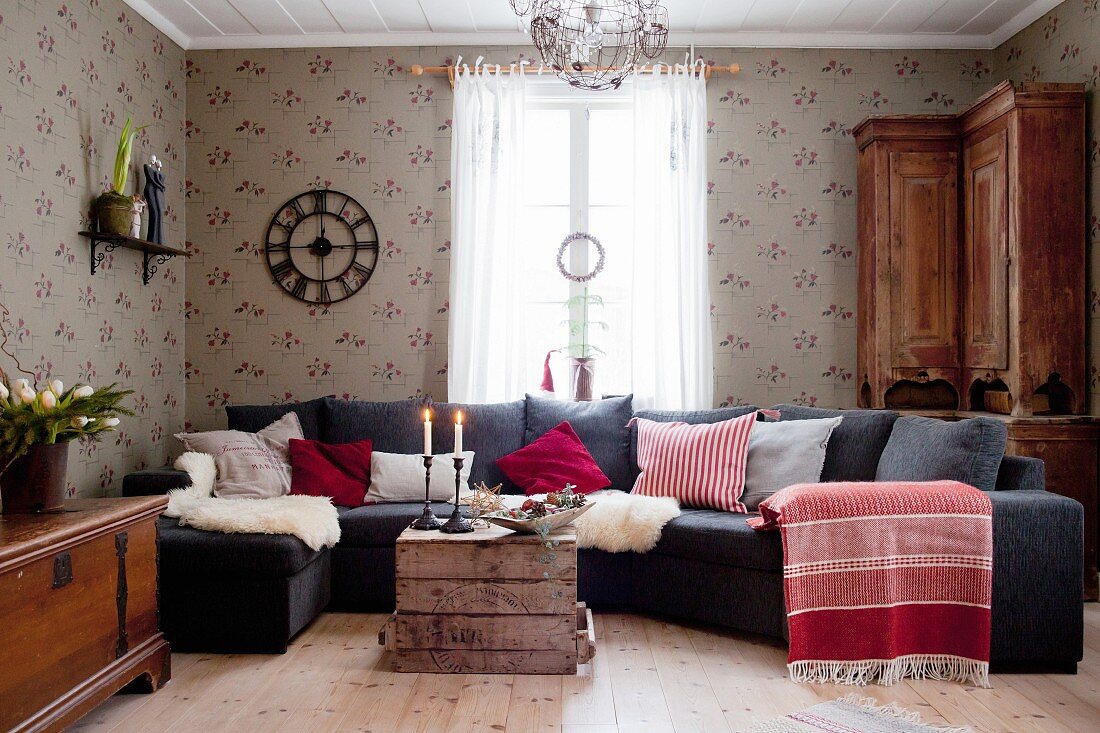 Sofalandschaft mit verschiedenen Kissen und Schaffellen in skandinavischem Wohnzimmer
