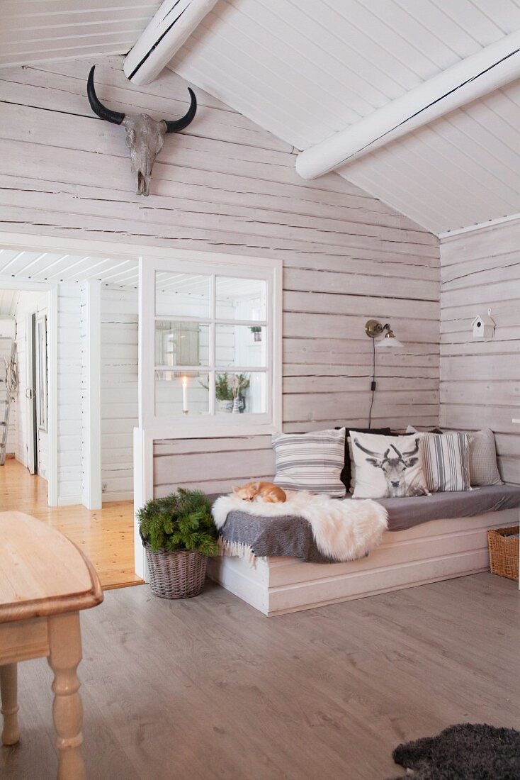 Comfortable couch in wintry wooden house