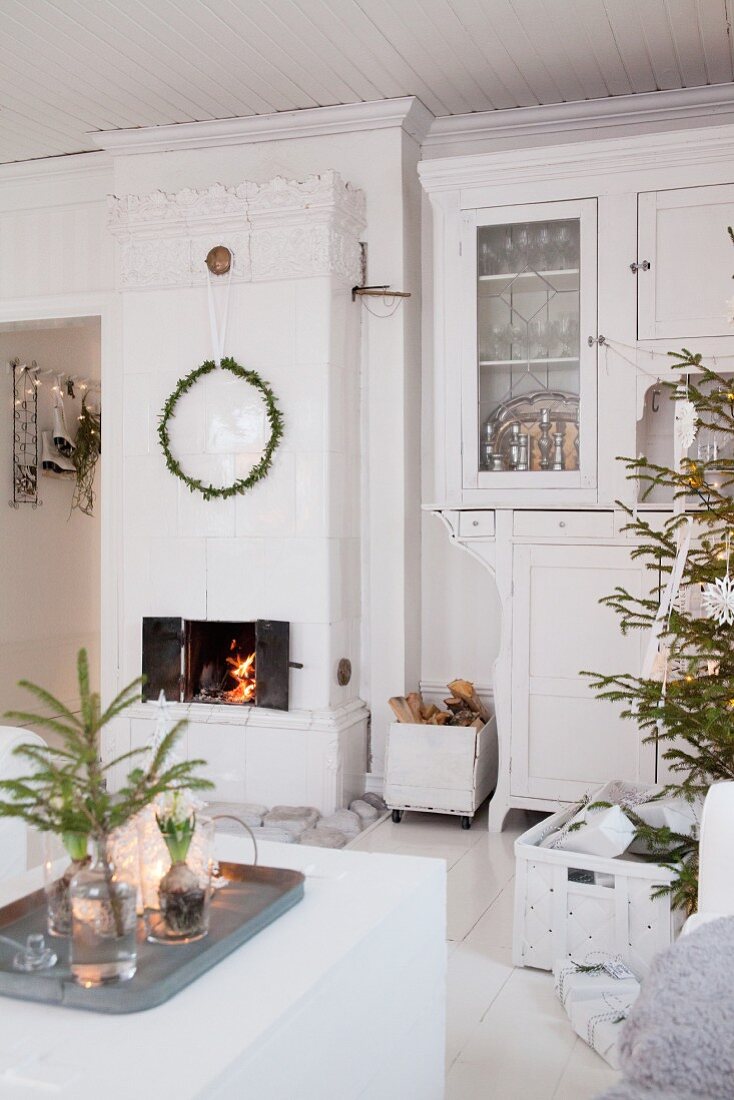 White, festive living room with Swedish tiled stove