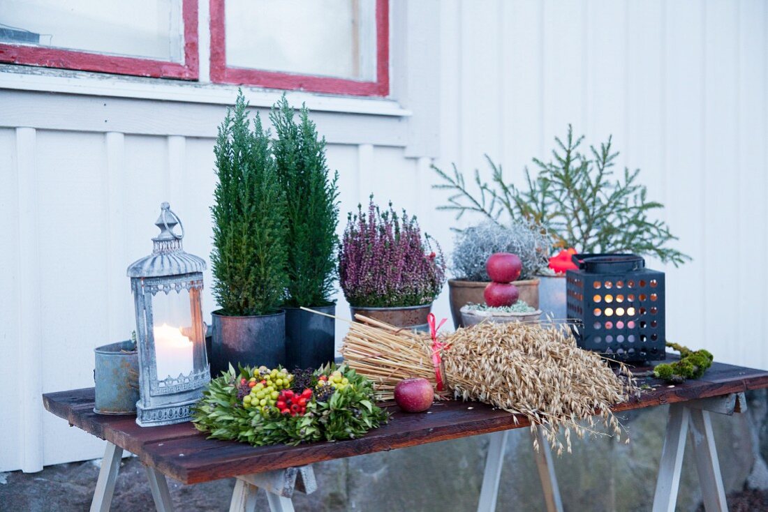 Winterlich dekorierter Tisch mit Laternen vor dem Haus