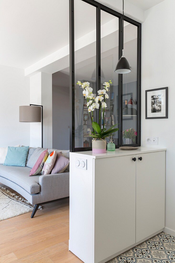 Partition made from interior window with black frame on top of white cabinet