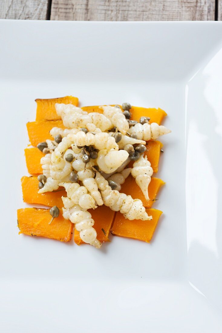 Lukewarm Japanese artichoke salad with capers on a bed of pumpkin