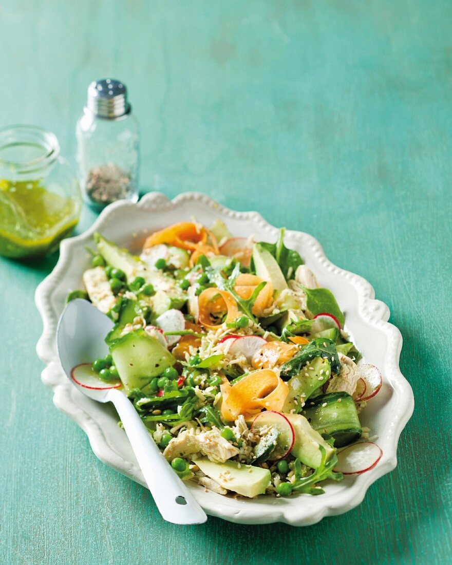 A vegetable salad full of vitamins with peas, avocado, cucumber and chicken