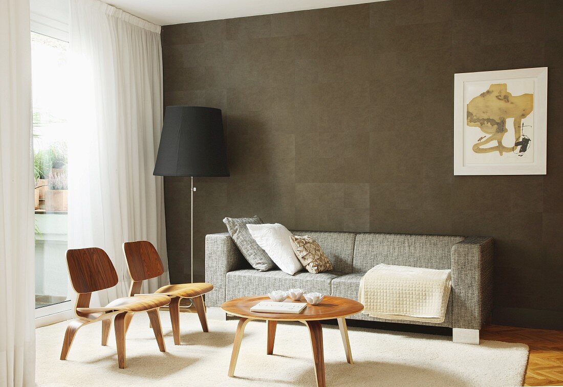 Classic chair, coffee table, sofa and standard lamp in front of brown wall in living room