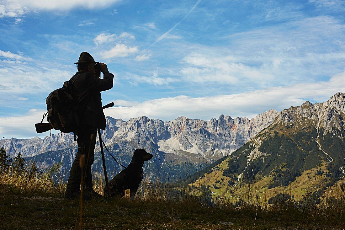 A hunter with a hound in a mountain setting