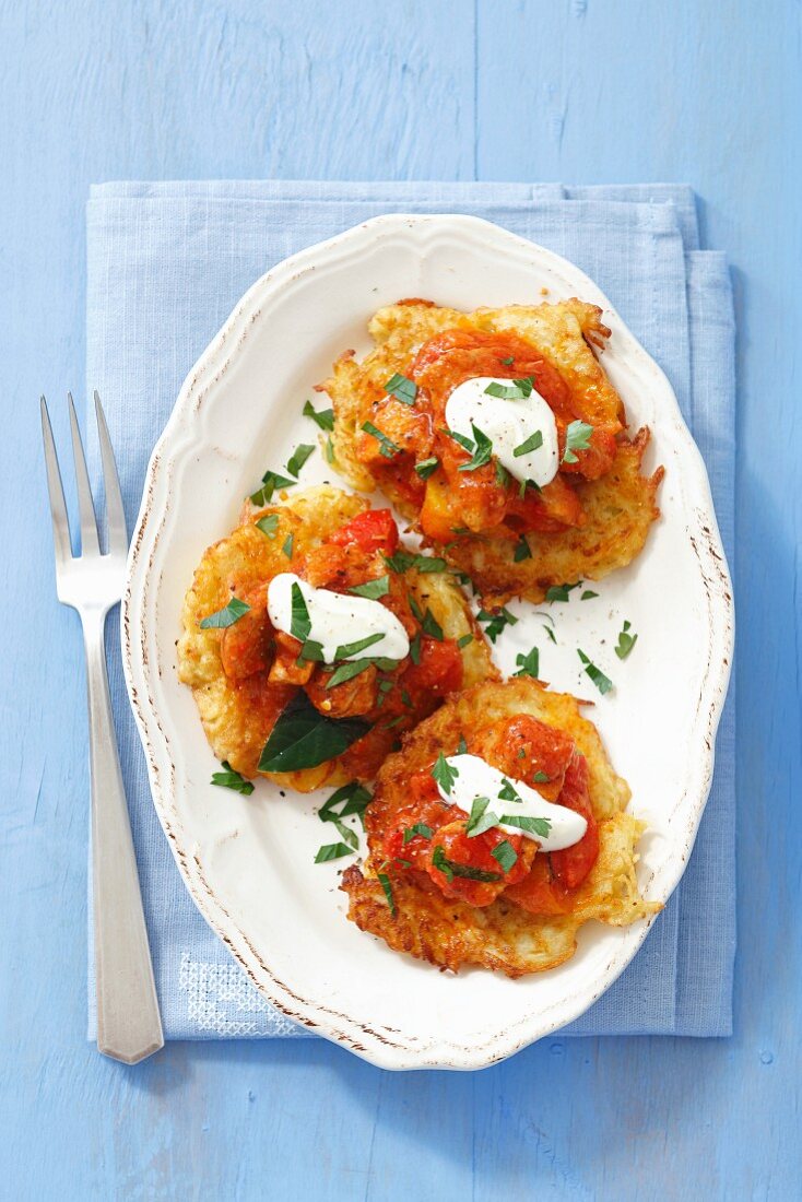 Potato fritters with pork goulash (pork, tomatoes and pepper) and sour cream