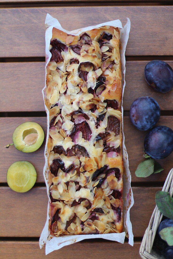 Plum cake and fresh plums (seen from above)