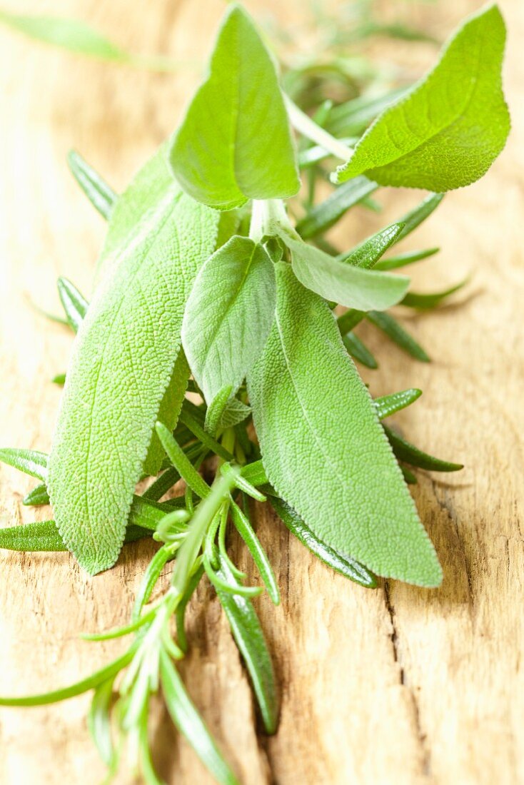 Fresh sage and rosemary on a wooden surface