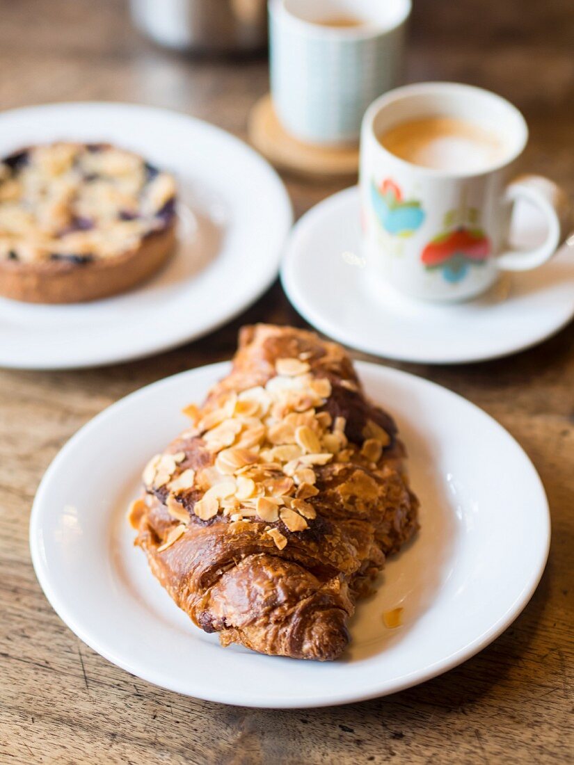 An almond croissant served with coffee in a café in France