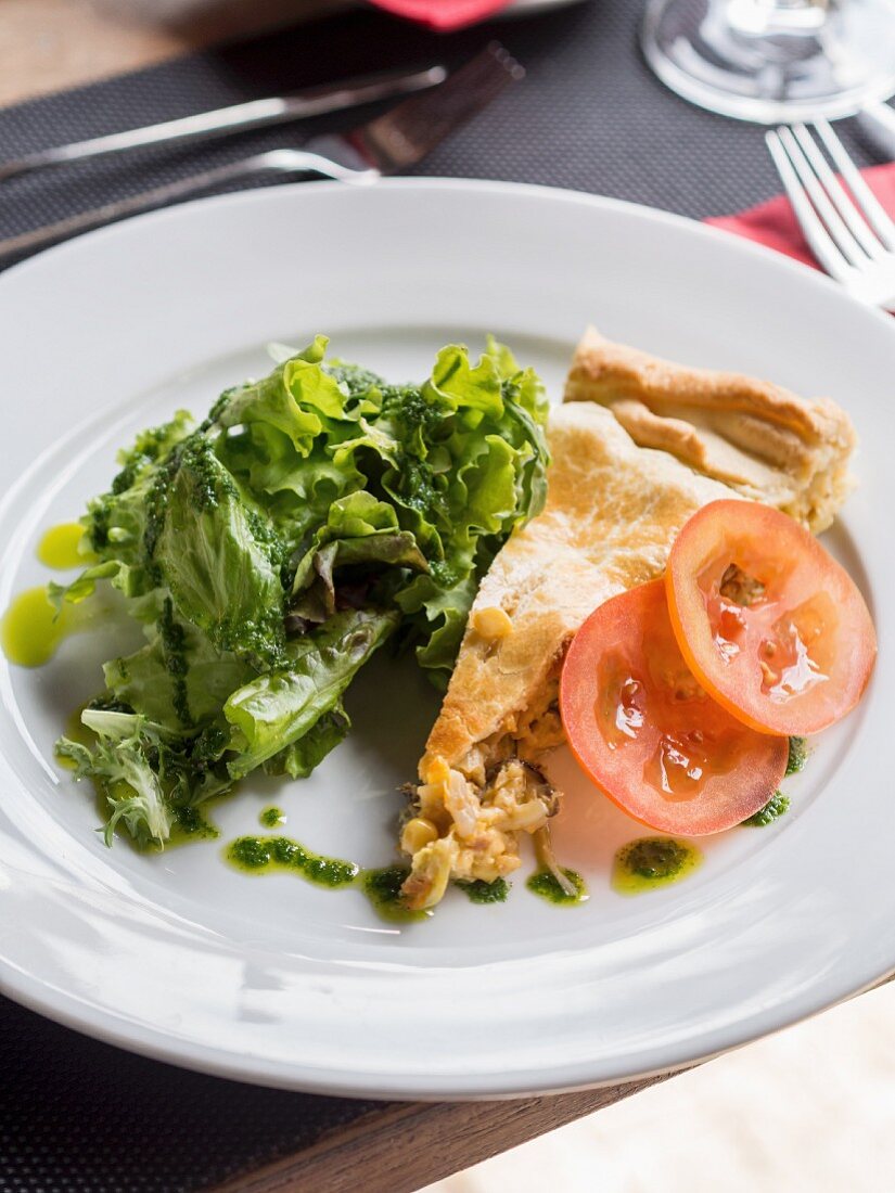 A slice of vegetable pie with mushrooms, soya and chorizo, served with salad