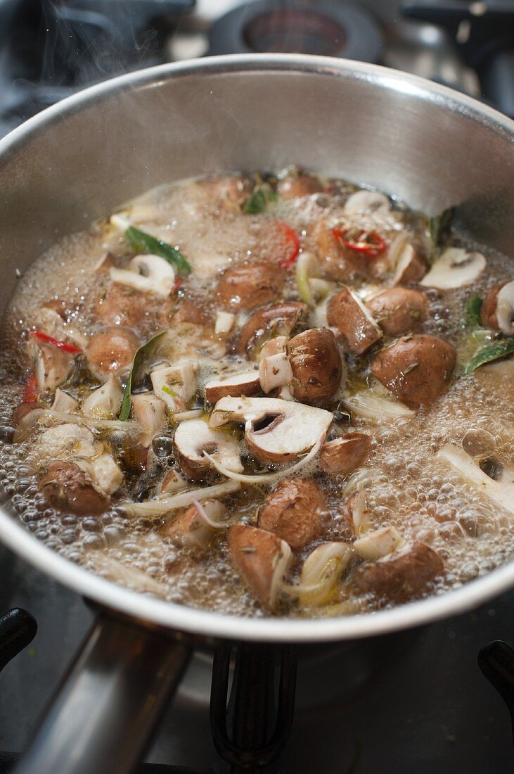 Marinierte Champignons in der Pfanne einkochen