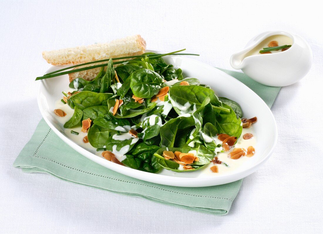 Baby leaf spinach with cheese sauce and flaked almonds