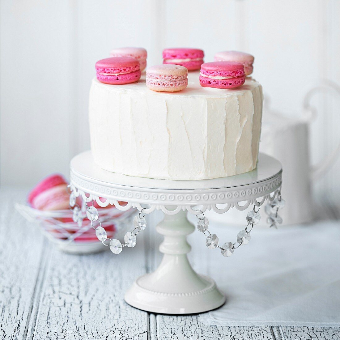 Weisser Schichtkuchen mit rosa Macarons dekoriert