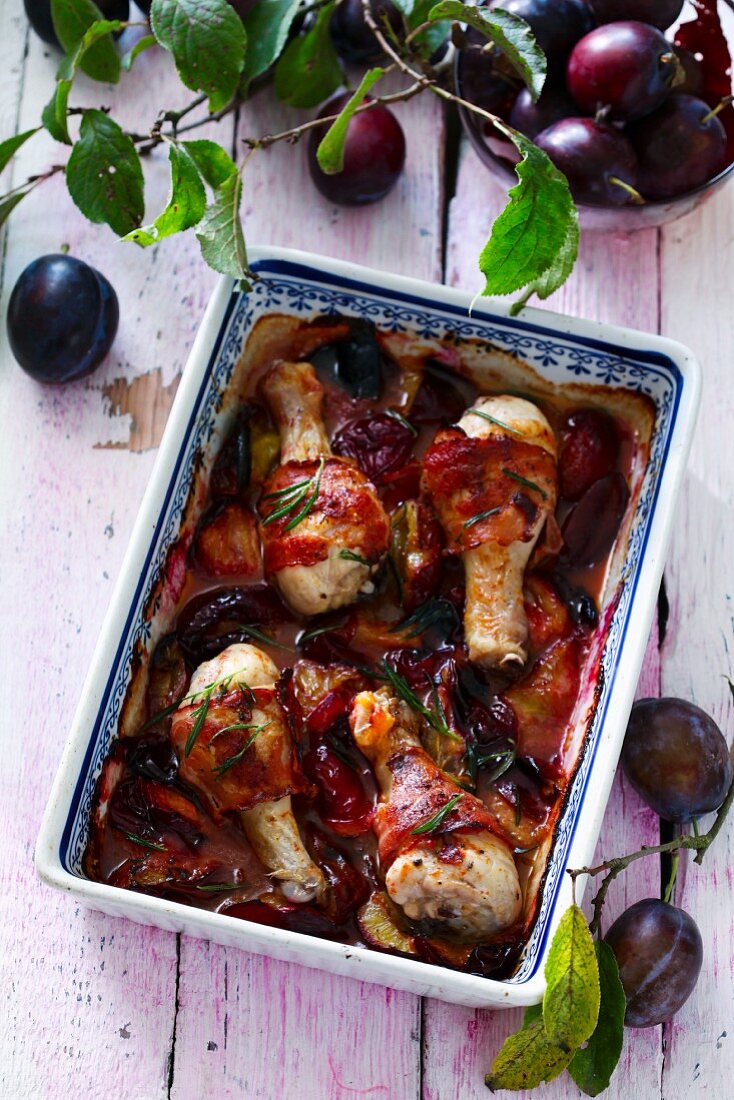 Chicken drumsticks with bacon and plums