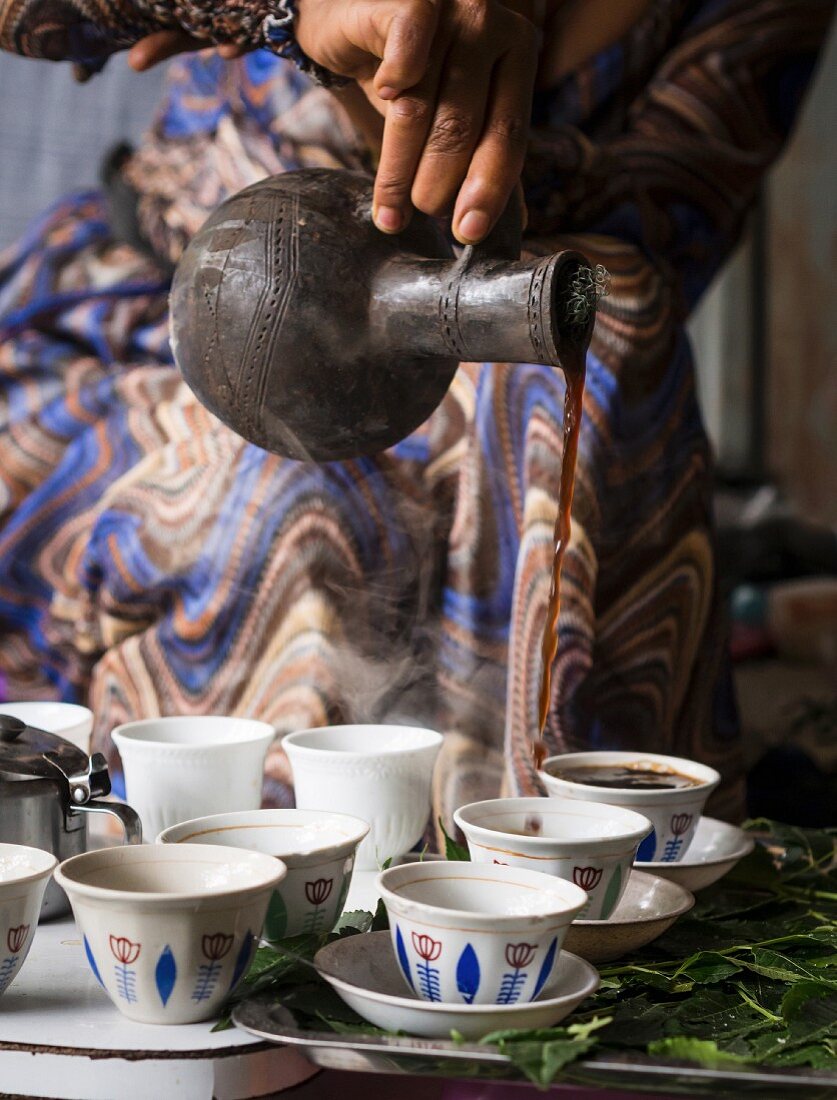 Frau serviert Kaffee aus Jabena während der traditionellen Kaffeezeremonie in Äthiopien