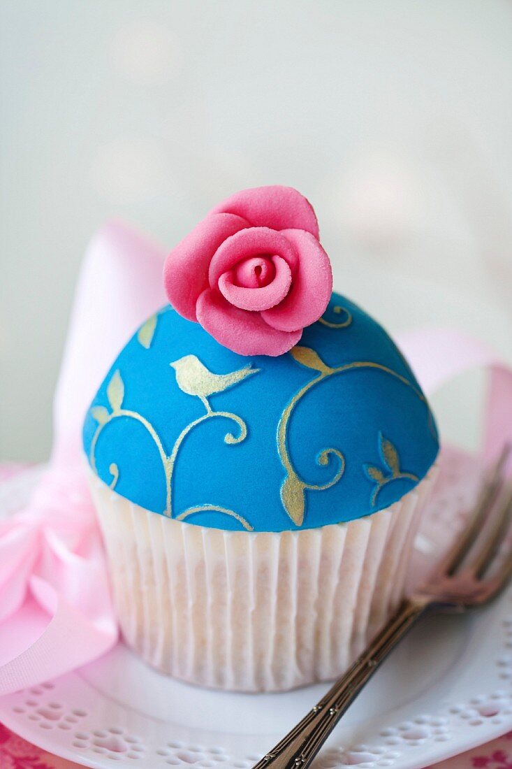 Cupcake decorated with gold embossing and a sugar rose