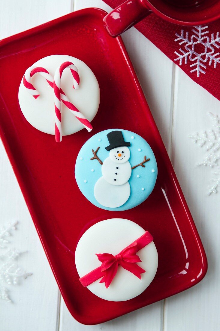 Weihnachtliche Cupcakes auf rotem Tablett