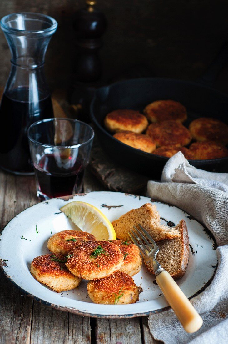 Fishcakes in breadcrumbs with a slice of bread and lemon