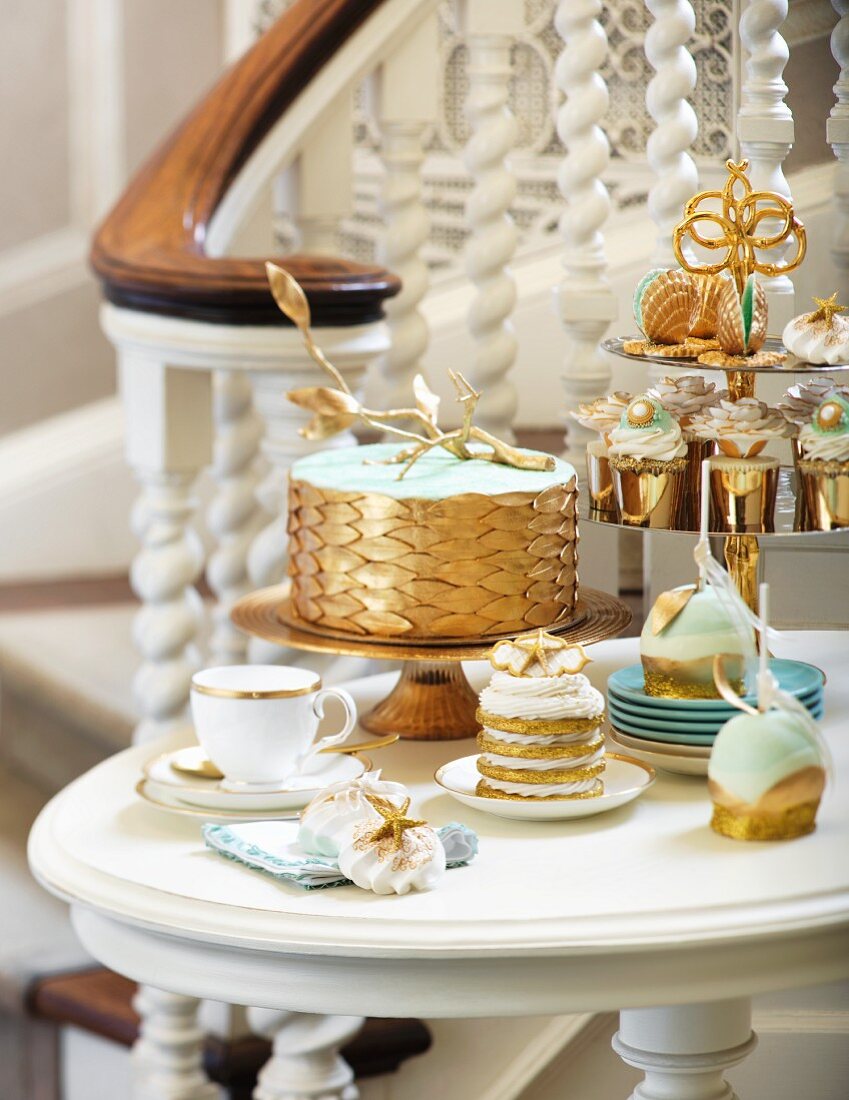 A cake and desserts in white and gold for a wedding