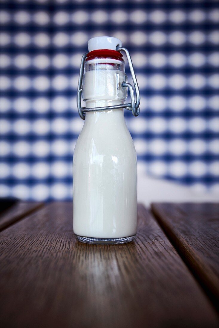 A small bottle of milk on a wooden table