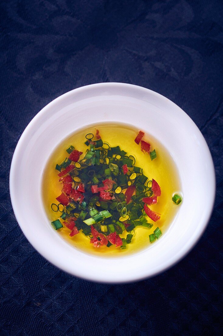 Vinaigrette with chives in a bowl (seen from above)
