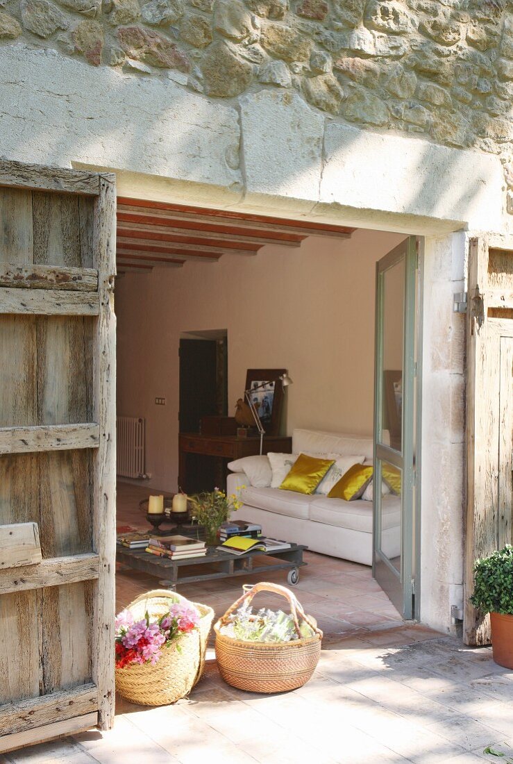 Flowers in shopping baskets in front of lounge area of renovated country house