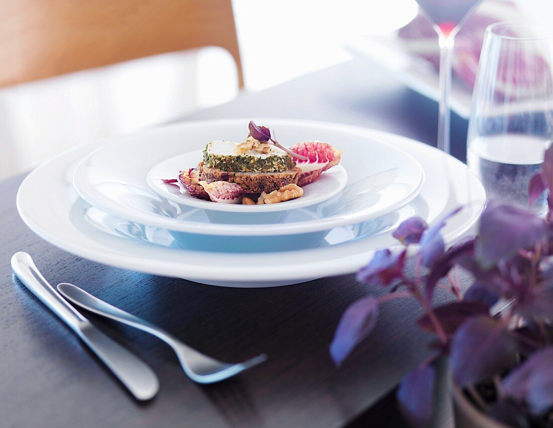 A starter plate containing bread topped with herb cream cheese and walnuts