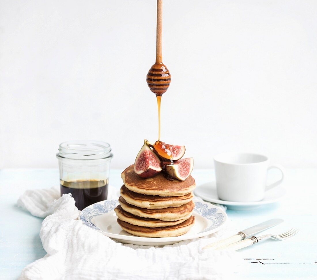 Turm aus Pancakes mit frischen Feigen und fliessendem Honig