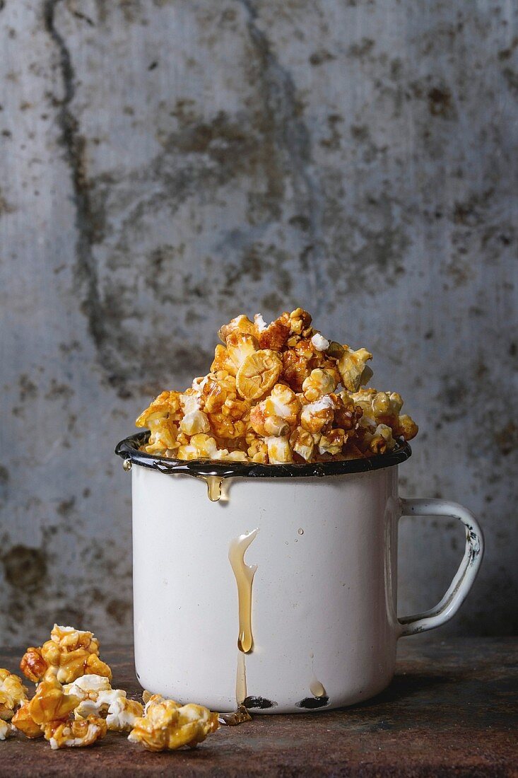 Karamellisiertes Popcorn in weisser Emaille-Tasse