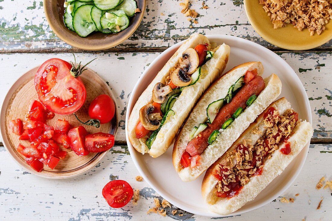 Assortment of homemade hot dogs with sausage, fried onion, tomatoes and cucumber, served with ingredients