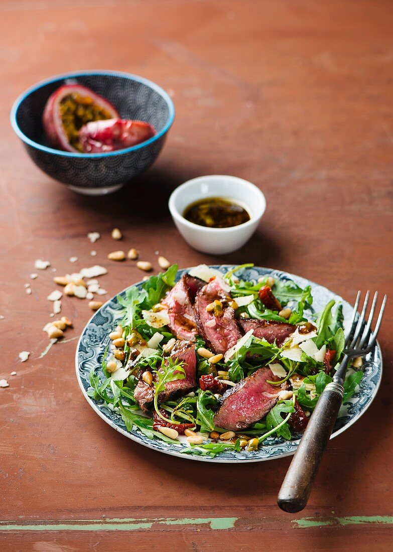 Beef steak with rocket, dried tomatoes and passionfruit & balsamic vinegar dressing