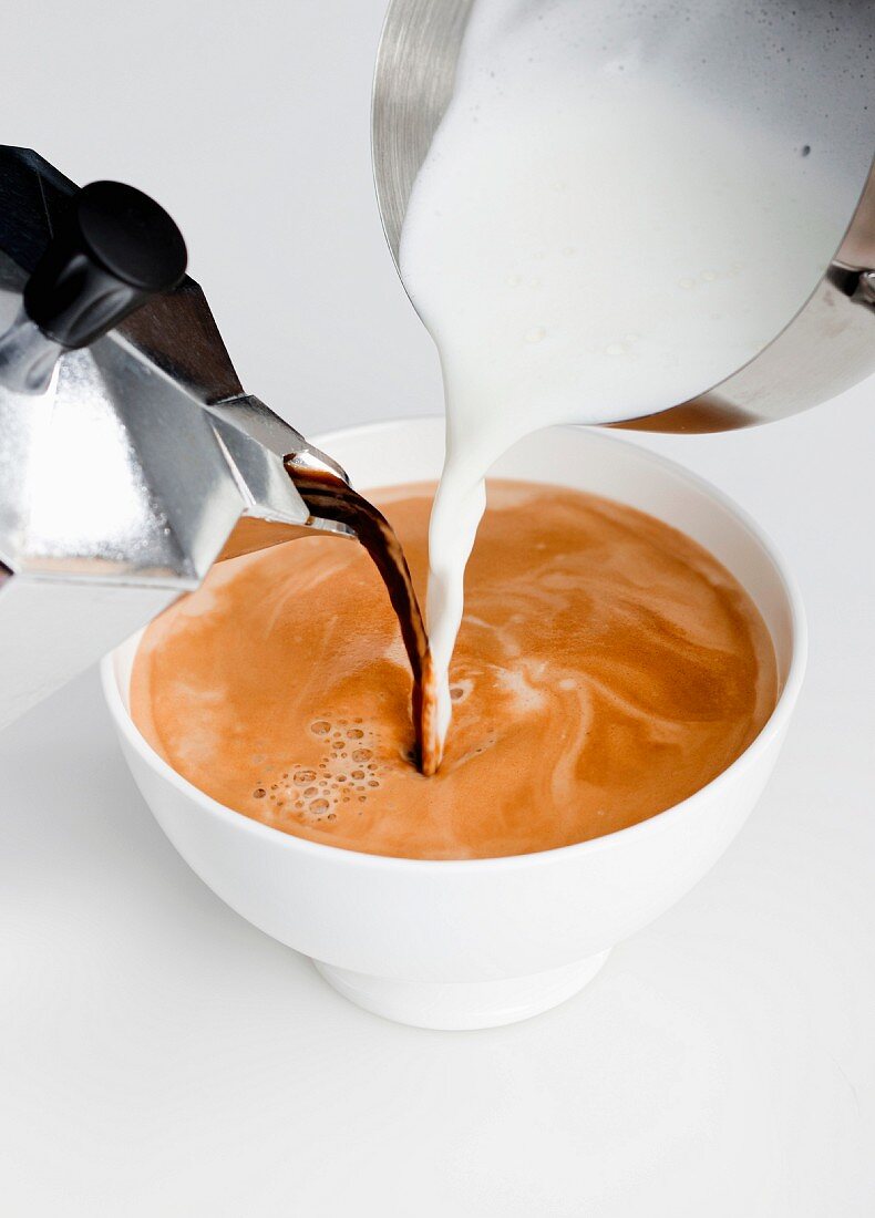 Espresso and milk being poured into a cup