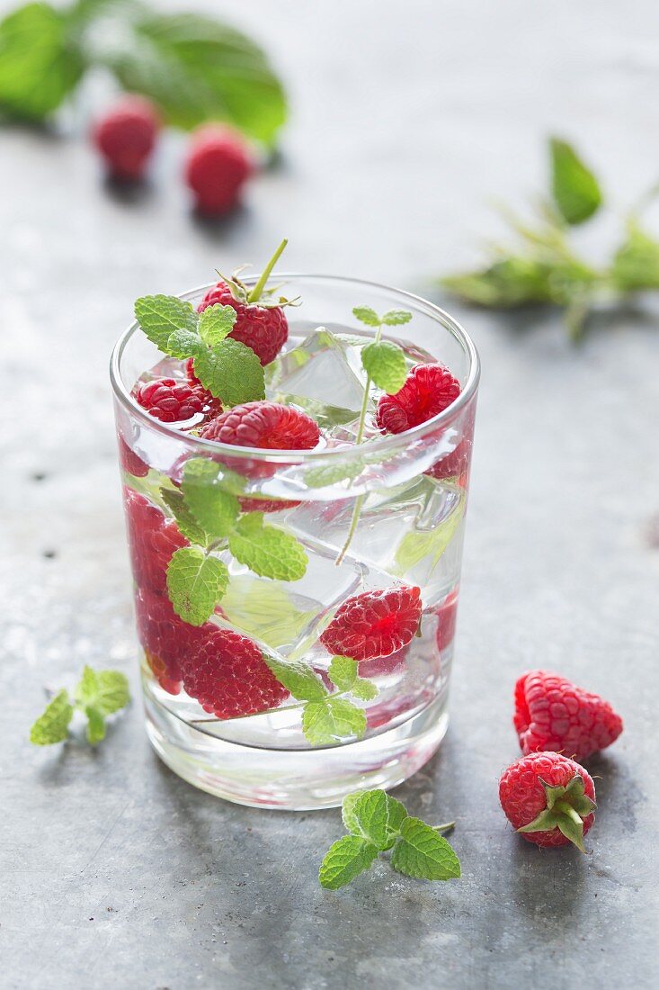 Water with raspberries, mint and ice cubes