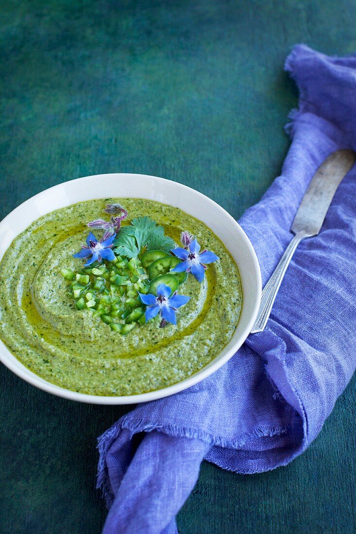 Roasted Jalapeno Cilantro Pesto in a ceramic bowl topped with jalapeno, cilantro and borage flowers