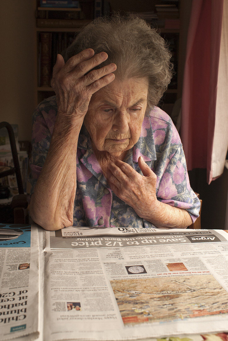 Elderly woman reading a newspaper