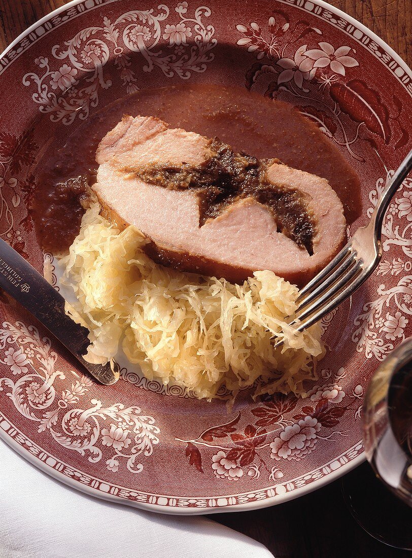Smoked pork stuffed with plums and sauerkraut on a plate