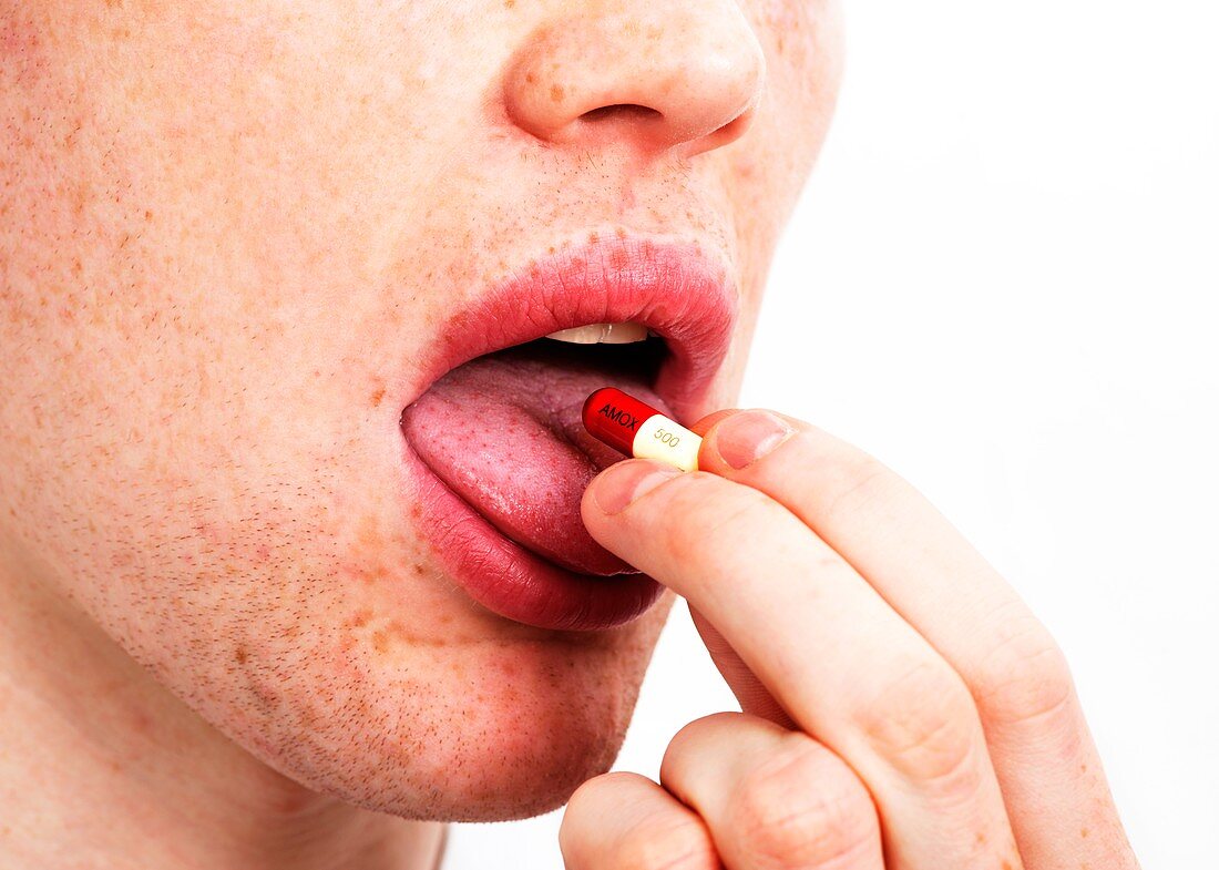 Man taking an antibiotic capsule