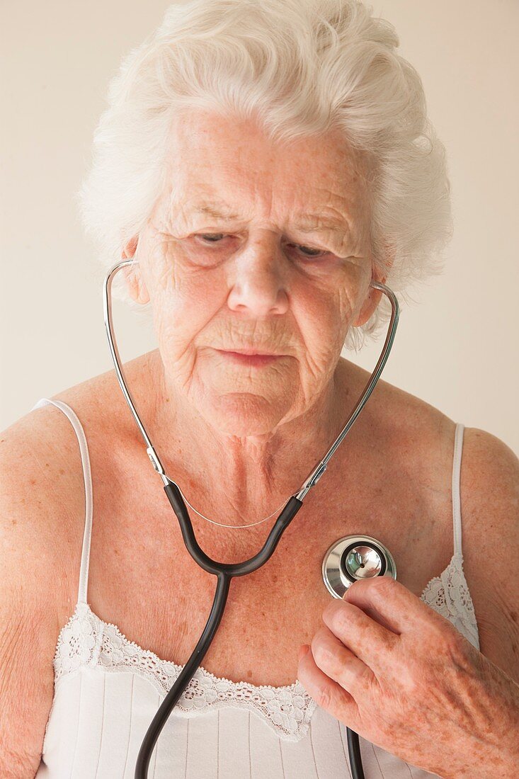 Elderly woman using a stethoscope