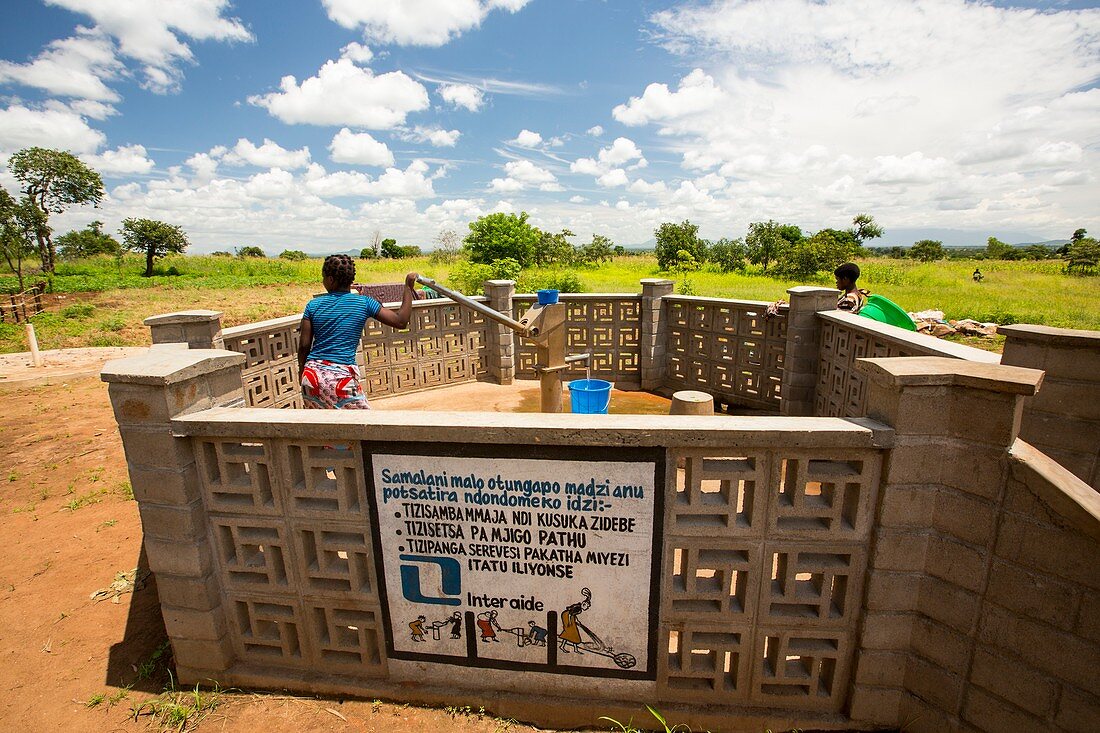 Woman using a water pump,Malawi