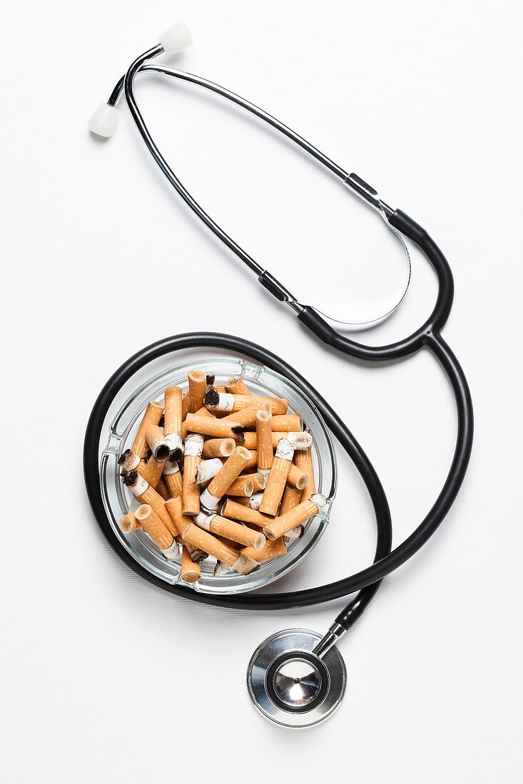 Cigarettes in ash tray with stethoscope