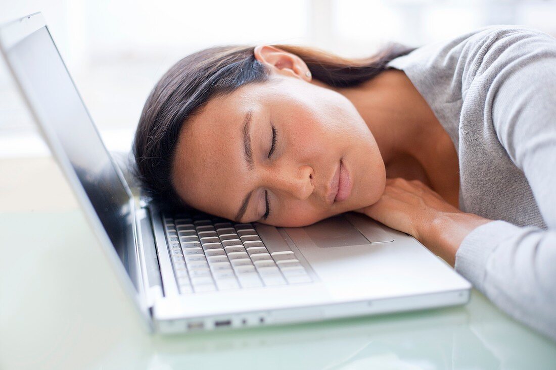 Young woman asleep on laptop