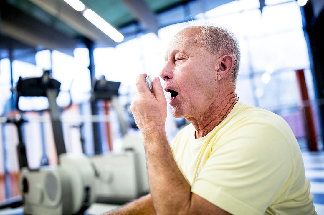 Senior man using inhaler