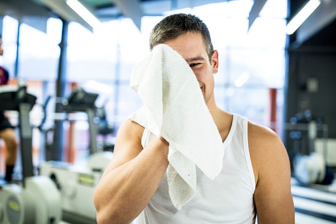Young man wiping his sweat with towel