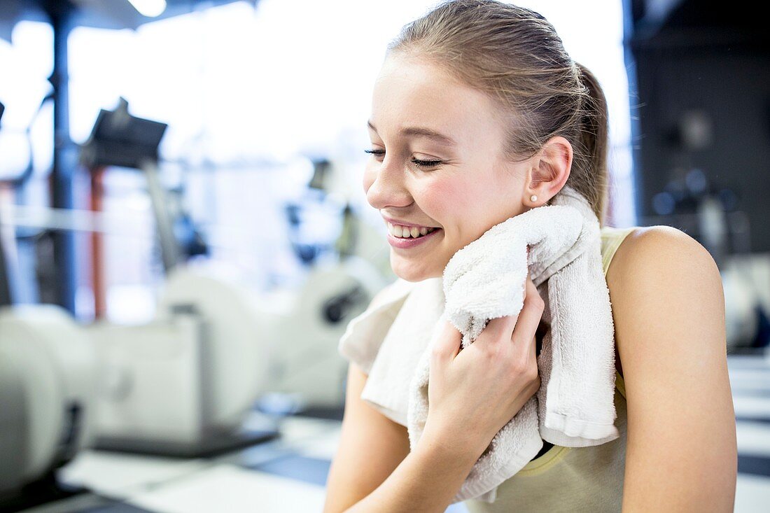 Young woman wiping her sweat with towel