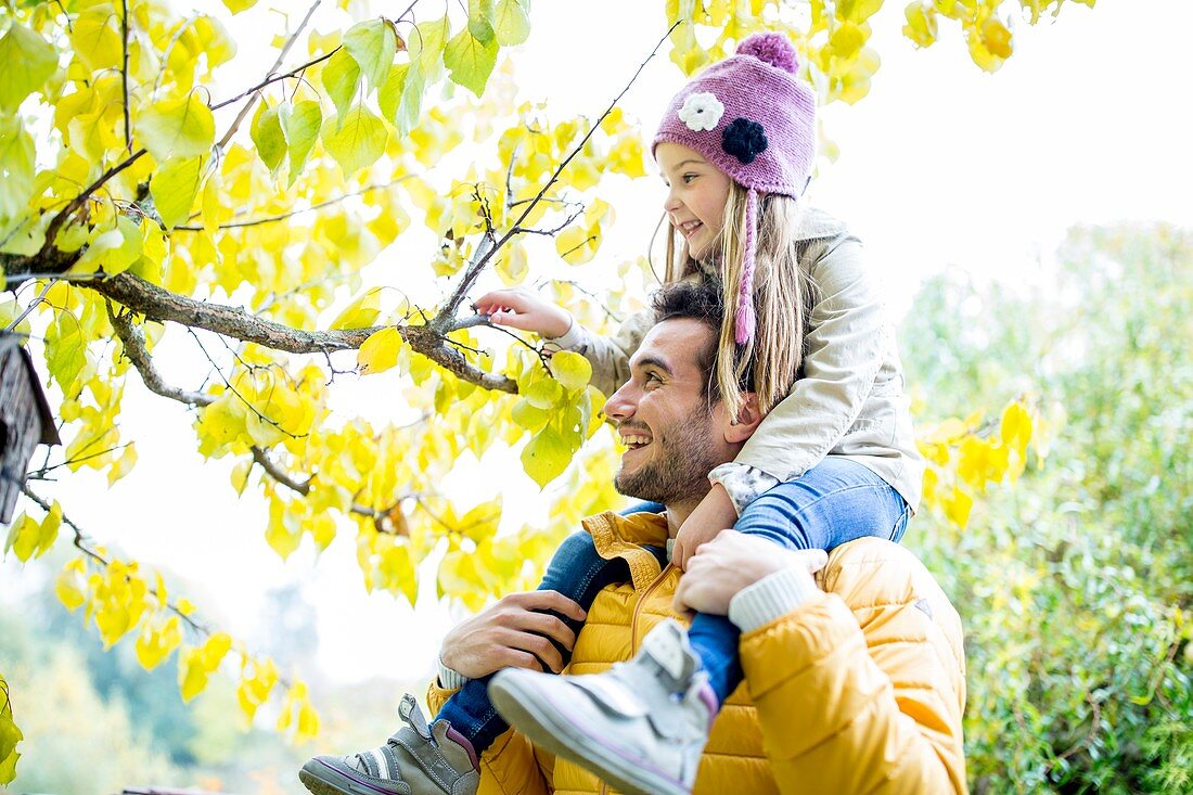 Father and daughter looking at branch