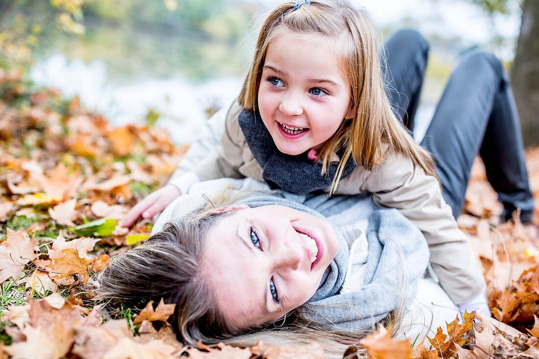Mother and daughter lying on leaves