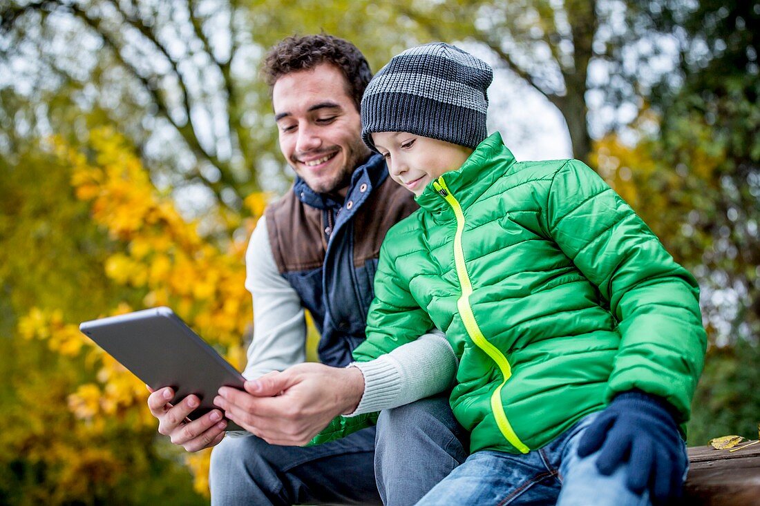 Man and boy using digital tablet