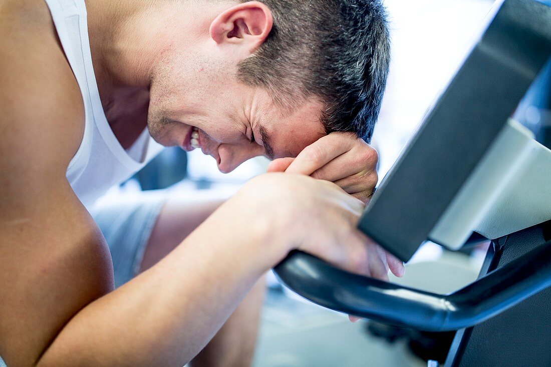 Man resting his head on exercise machine