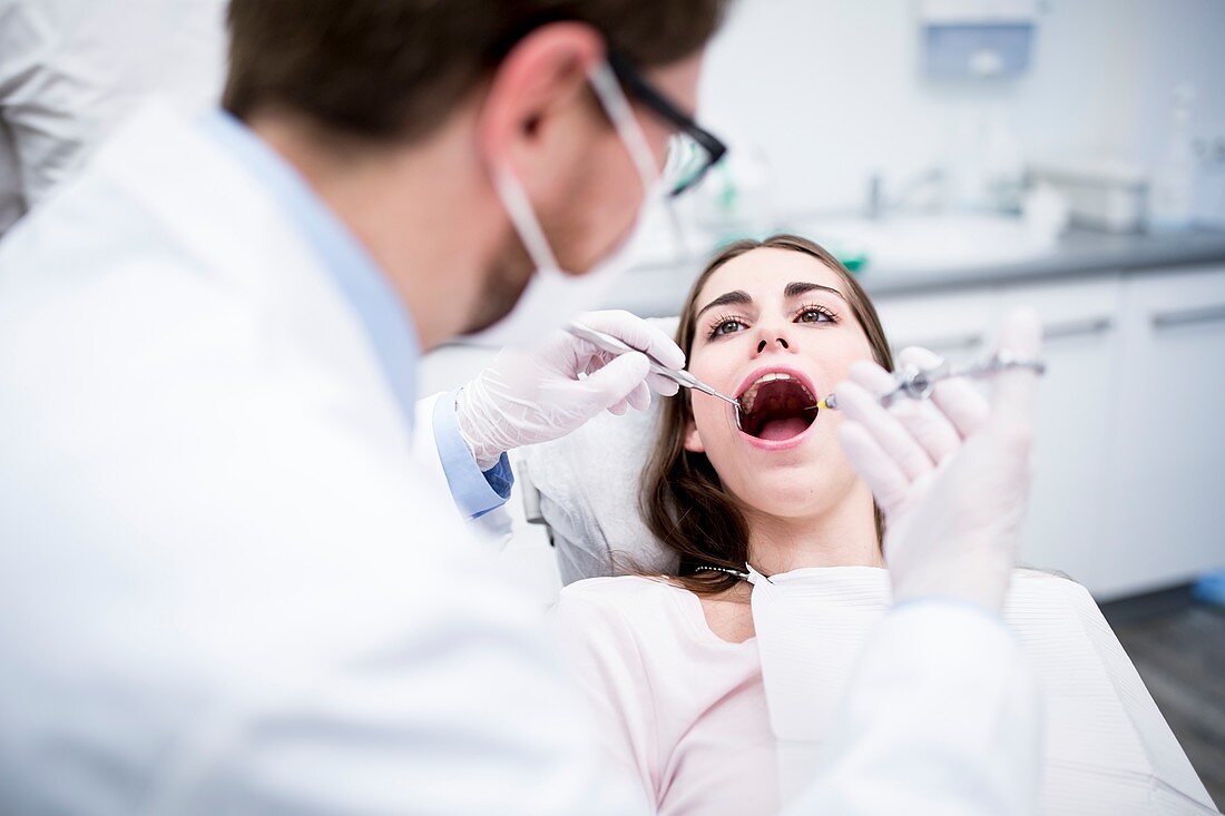 Dentist anesthetizing patient