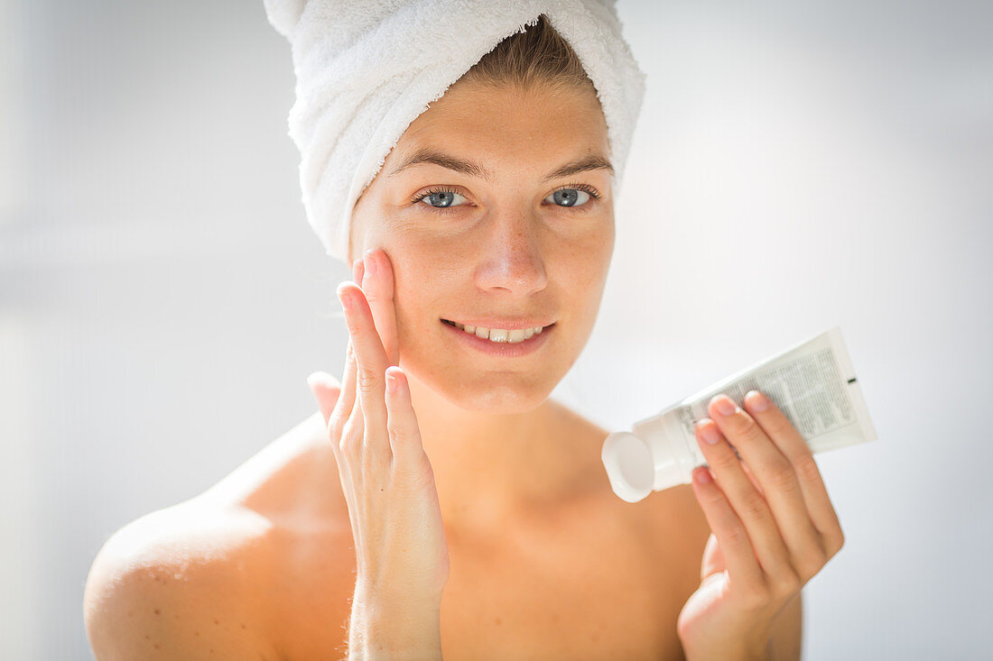 Woman applying moisturizing cream
